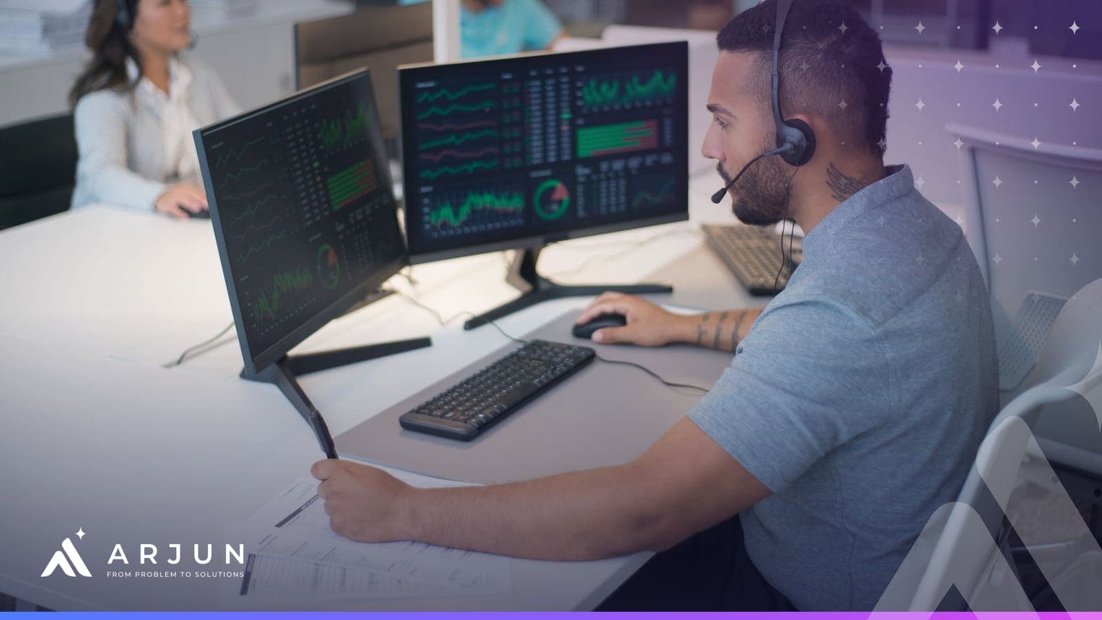 An operations specialist with a headset working across two monitors of dashboards in an office