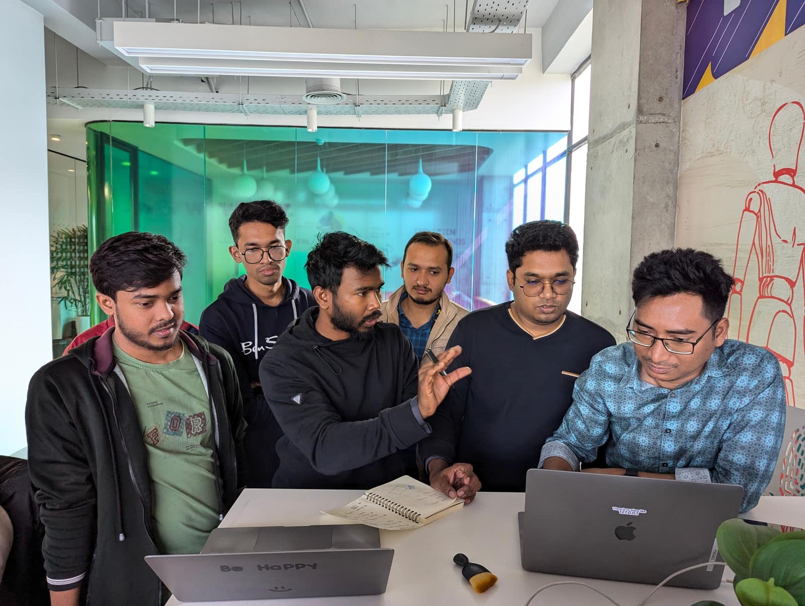 A group of young professionals working together around a laptop