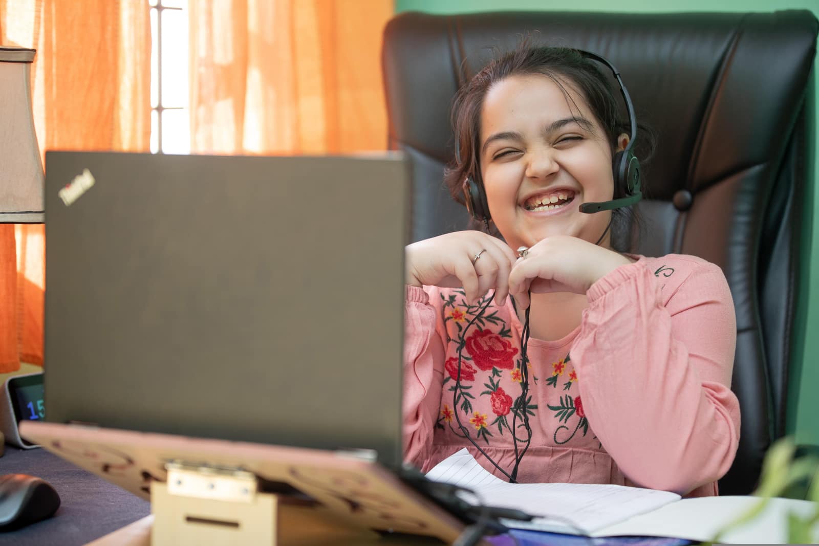 A student with a headset joining an online class from home
